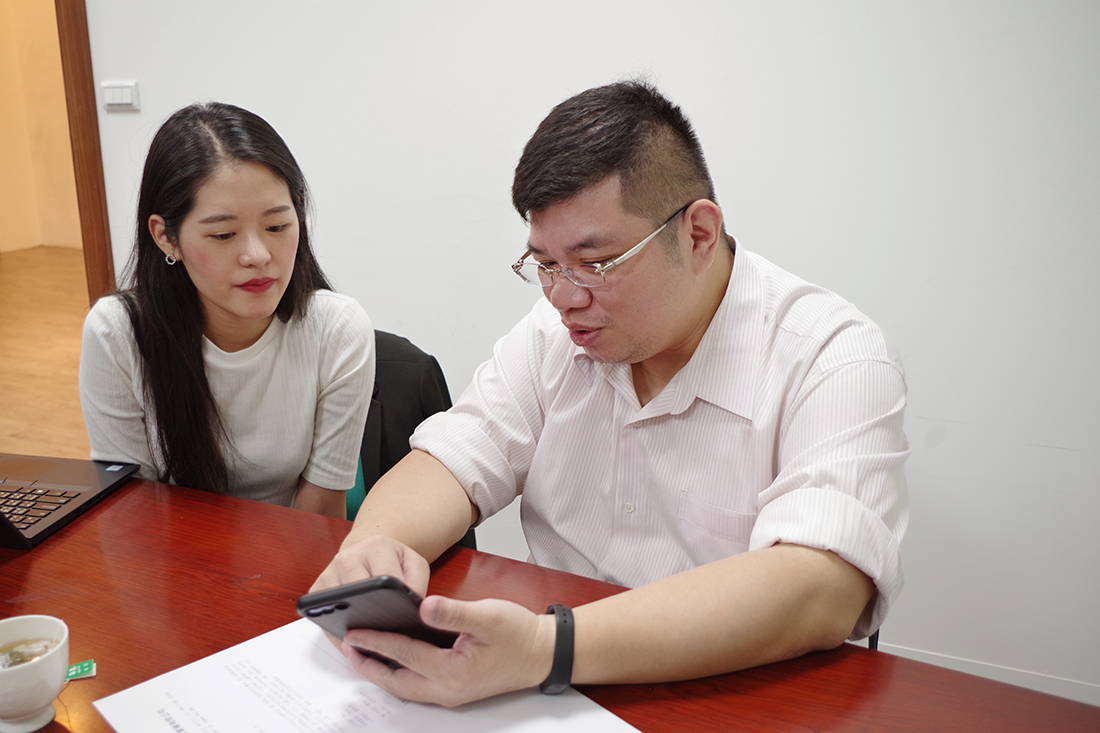 照片為阡隆科技Mars向專員討論用手機開啟檔案